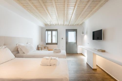 a white room with two beds and a tv at Fabrikas in Mýkonos City