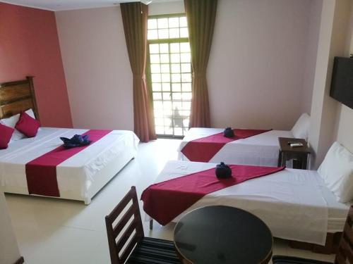 a hotel room with two beds and a table and a chair at Answer hotel in Puerto Galera