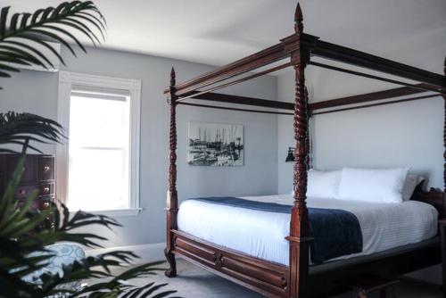 ein Schlafzimmer mit einem Himmelbett und einem Fenster in der Unterkunft Emerson Inn By The Sea in Rockport