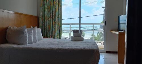 a hotel room with a bed with a large window at Flat 305 - Flat no Vip Praia Hotel in Natal