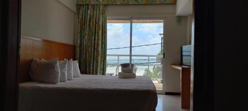 een slaapkamer met een bed en een groot raam bij Flat 305 - Flat no Vip Praia Hotel in Natal