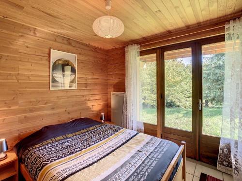 une chambre avec un lit dans une cabane en rondins dans l'établissement Chalet cosy 10 pers, terrasse sud, park, à 50m des pistes et commerces - FR-1-416-10, à La Toussuire