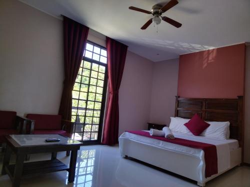 sypialnia z łóżkiem, stołem i oknem w obiekcie Answer hotel w mieście Puerto Galera