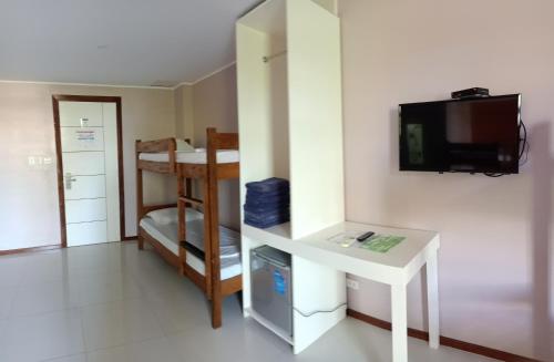 um pequeno quarto com uma secretária e uma televisão na parede em Answer hotel em Puerto Galera
