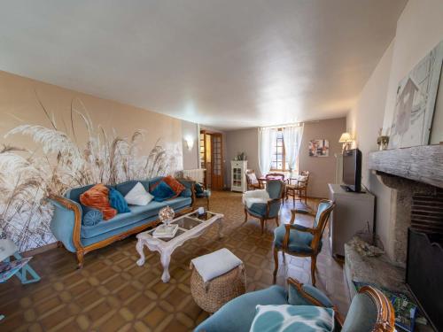 a living room with a blue couch and a fireplace at Maison d'époque avec sauna, jacuzzi et salle de jeux à 1h de Paris - Idéale familles/amateurs de stages - FR-1-590-4 in Boisseaux