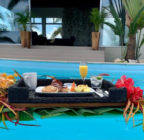 a tray of breakfast food on a table next to a pool at Waterfield Villa in Montego Bay