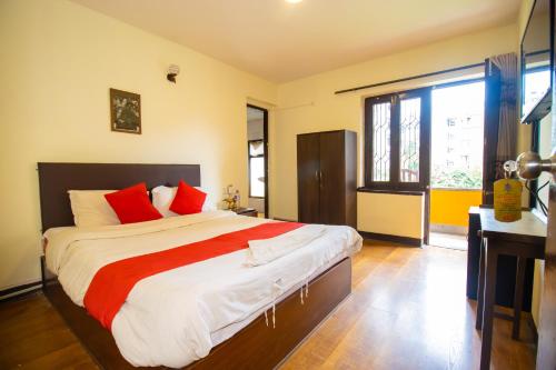 een slaapkamer met een groot bed met rode kussens bij Tibet Peace Guest House in Kathmandu
