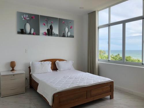 a bedroom with a bed and a large window at Hotel,Căn Hộ Mũi Né Sea link in Phan Thiet