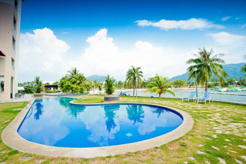 a swimming pool in a resort with palm trees at Marina Island Pangkor Resort & Hotel in Lumut