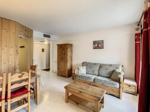 un salon avec un canapé et une table dans l'établissement Appartement lumineux 6 pers, style montagne, balcon sud, proche commerces et pistes - FR-1-417-151, à La Toussuire