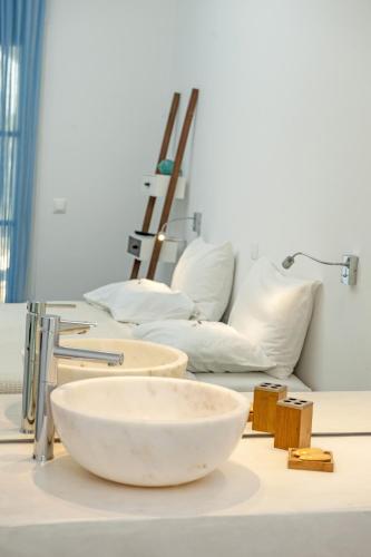 a white bowl on a table with pillows at Margarita Studios Ambelas in Ambelas