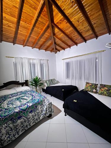 a bedroom with two beds and a ceiling with windows at Villa Celeste in Doradal