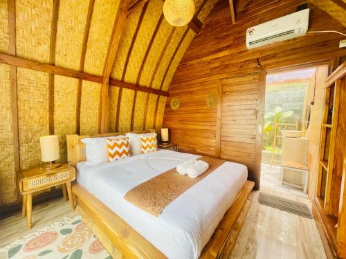 een slaapkamer met een groot bed in een houten kamer bij Batur Panorama in Kintamani