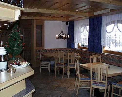 a dining room with a table and chairs and a christmas tree at Hotel Sturpen in Sankt Leonhard im Pitztal