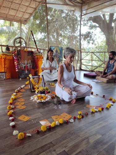 a woman sitting on the floor in a circle of flowers at TantraLoka Retreat Centre in Arambol