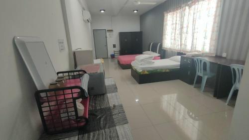 um quarto de hospital com duas camas e uma mesa e cadeiras em Baoyousongsong em Kampar
