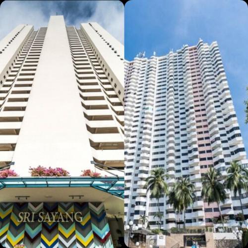 a large white building with palm trees in front of it at Batu Ferringhi Luxury Seaview Suite - 3Br in Batu Ferringhi