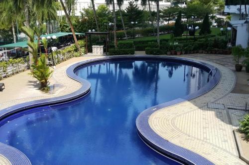 a large blue swimming pool in a resort at Batu Ferringhi Luxury Seaview Suite - 3Br in Batu Ferringhi