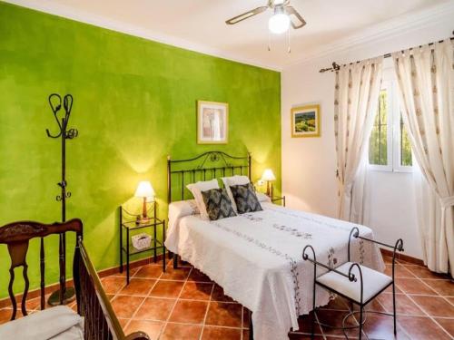 1 dormitorio con paredes verdes y 1 cama en Appealing holiday home in Andaluc a with private pool, en La Joya