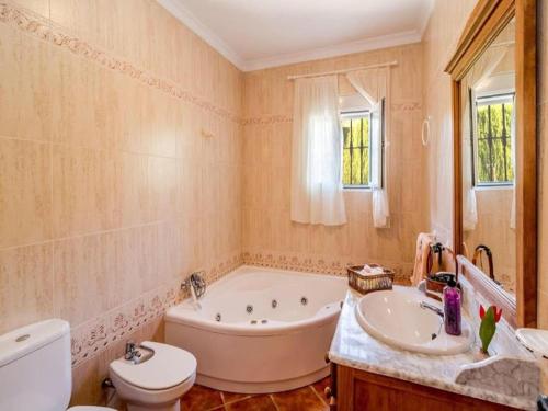 y baño con bañera, aseo y lavamanos. en Appealing holiday home in Andaluc a with private pool, en La Joya