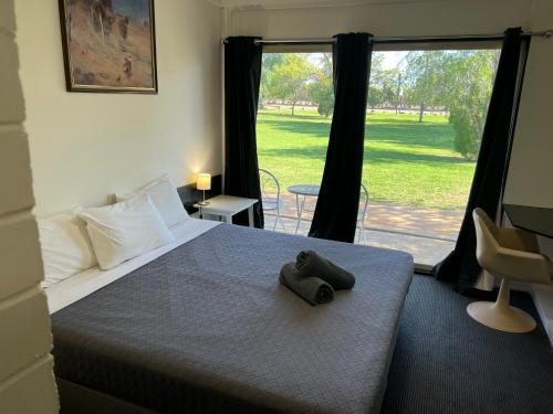 1 dormitorio con cama y ventana grande en Jumbuck Motor Inn - POOL - PET FRIENDLY SECTION - KING BEDS, en Longreach