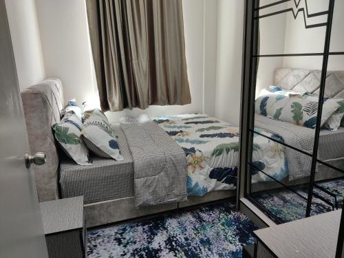 einen Spiegel in einem Zimmer mit einem Bett und einem Sofa in der Unterkunft D DAIM HOMESTAY @ PRIMA MERU in Ipoh