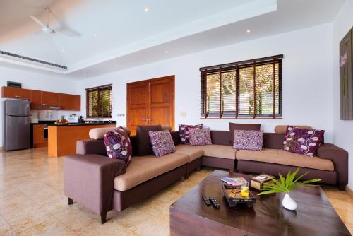 a living room with a couch and a table at Villa Baan Saitara in Lamai