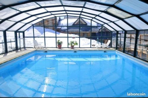una piscina coperta con tetto in vetro di Saint François Longchamps Loc à la Montagne avec piscine été hiver vg23 a Saint-François-Longchamp