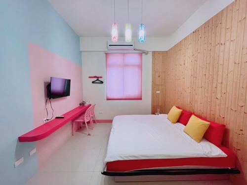 馬公市的住宿－樂在綺中民宿 第580號，一间卧室配有一张带红色和黄色枕头的床