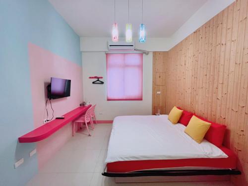 a bedroom with a bed with a red and yellow pillows at 澎湖樂在綺中民宿 第580號 in Magong