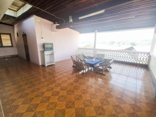 a room with a table and chairs on a balcony at Manilath guesthouse in Ban Houayxay