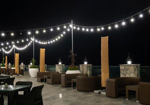a dining area with tables and chairs and lights at Basqal Resort & SPA in Basqal