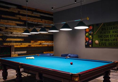 a billiard table in a room with a wall with avertisement at Basqal Resort & SPA in Basqal