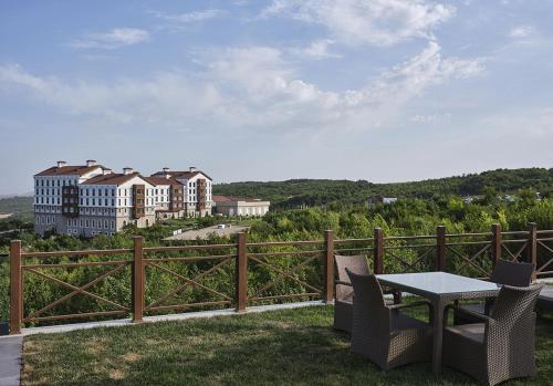 a table and chairs on a balcony with a building at Basqal Resort & SPA in Basqal