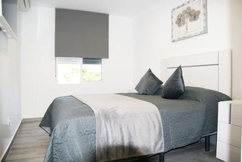 Dormitorio blanco con cama con manta gris en Bungalow in Lago Jardin I, LosBalcones,Torrevieja Luxury, en Los Altos