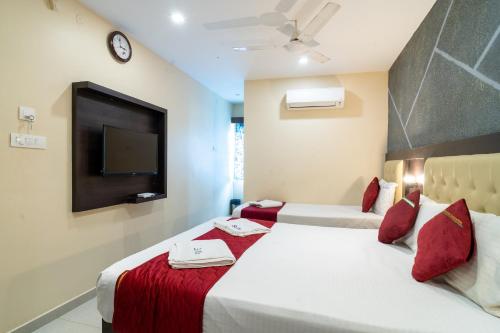 a hotel room with two beds and a tv at Safa Residency in Tiruchchirāppalli