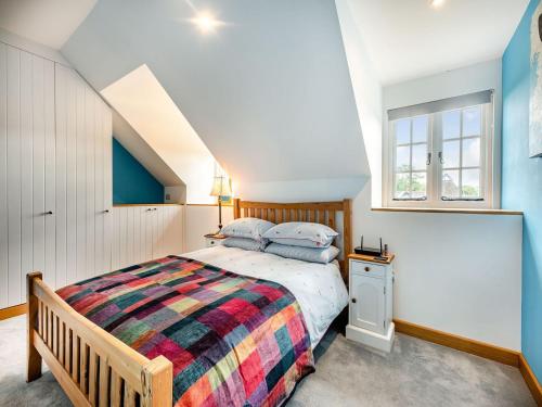 a bedroom with a bed with a colorful blanket at The Dog And Trout in Findon
