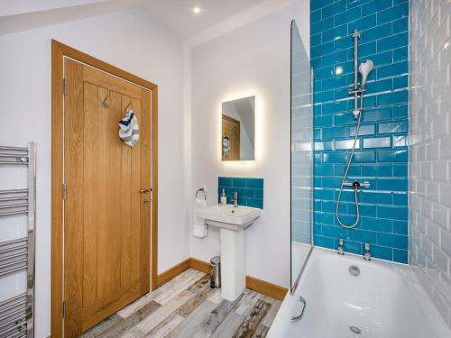 a bathroom with a tub and a sink and a shower at The Dog And Trout in Findon