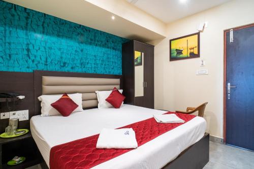 a bedroom with a large bed with red pillows at Safa Residency in Tiruchchirāppalli