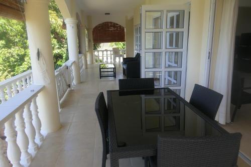 - un couloir d'une maison avec une table et des chaises dans l'établissement Tropical Garden Self Catering, à Victoria