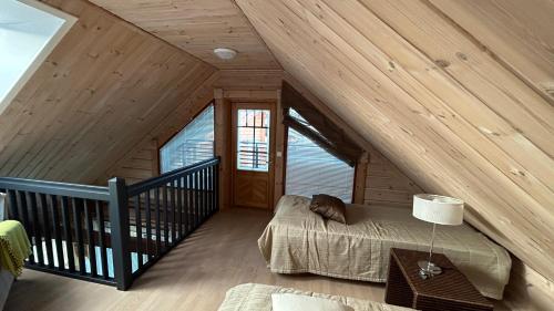 a bedroom with a bed in a attic at Villa Laakson Helmi 1 с камином, сауной, SPA, на берегу озера in Himos