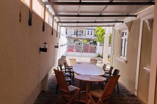 eine Terrasse mit einem Tisch und Stühlen in einem Gebäude in der Unterkunft Villa Palmira 6 suites avec piscine 5 min à pied de la plage Pereybere in Pereybere