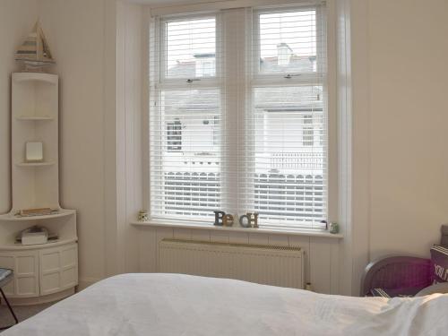 a bedroom with a bed and a large window at Hunter Links Cottage in Prestwick