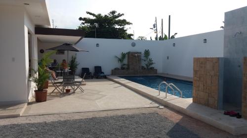 a house with a swimming pool and a table and chairs at LA ESCONDIDA in Tonsupa