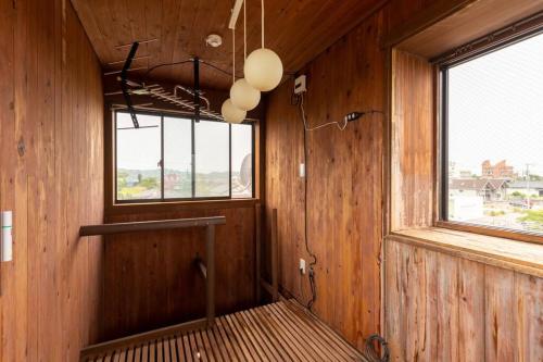 a room with wood paneled walls and a window at オーシャニア一宮 in Ichinomiya