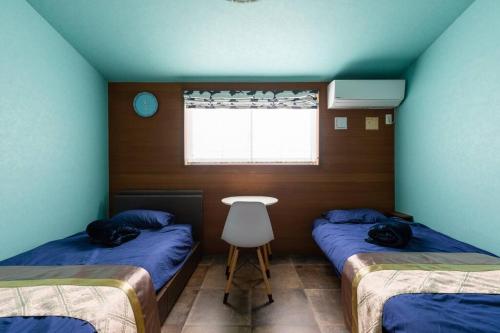 a room with two twin beds and a window at オーシャニア一宮 in Ichinomiya