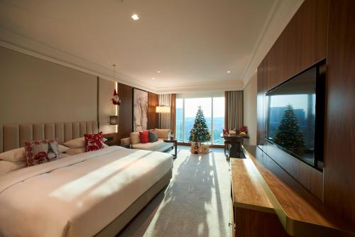 a bedroom with a large bed and two christmas trees at Grand Hyatt Dubai in Dubai