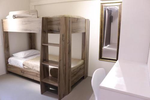 1 dormitorio con litera y espejo en Valmarin Seafront Apartments, en Trou d'Eau Douce