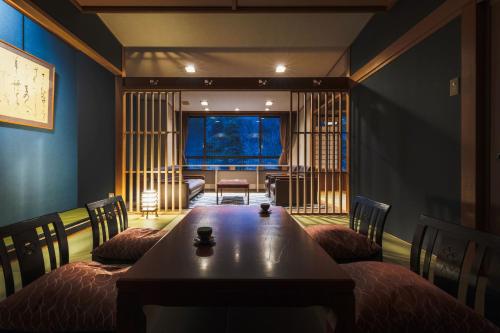 a room with a table and chairs and a living room at Takamiya Bettei Kuon in Tsuruoka
