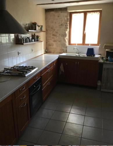 una cucina con lavandino e piano cottura forno superiore di Location meublée à caractère atypique a Puygouzon-et-Montsalvy